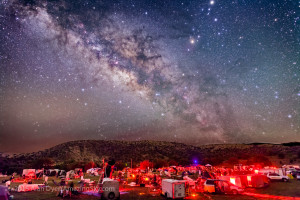 The galactic centre region of the Milky Way in Sagittarius and Scorpius, over the upper field of the Texas Star Party, near Fort Davis, Texas, May 13, 2015. About 600 people gather here each spring for a star party under very dark skies near the MacDonald Observatory. Sagittarius is left of centre and Scorpius is right of centre with the planet Saturn the bright object at the top edge right of centre. The dark lanes of the Dark Horse and Pipe Nebula areas lead from the Milky Way to the stars of Scorpius, including Antares. The semi-circular Corona Australis is just clearing the hilltop at left of centre. This is a composite of 5 x 3 minute exposures with the camera tracking the sky for more detail in the Milky Way without trailing. Each tracked exposure was at ISO 1600. The ground comes from 3 x 1.5-minute exposures at ISO 3200 taken immediately after the tracked exposures but with the drive turned off on the tracker. All are with the 24mm lens at f/2.8 and filter-modified Canon 5D MkII camera. The ground and sky layers were stacked and layered in Photoshop. The tracker was the Sky-Watcher Star Adventurer. High haze added the natural glows around the stars — no filter was employed here.